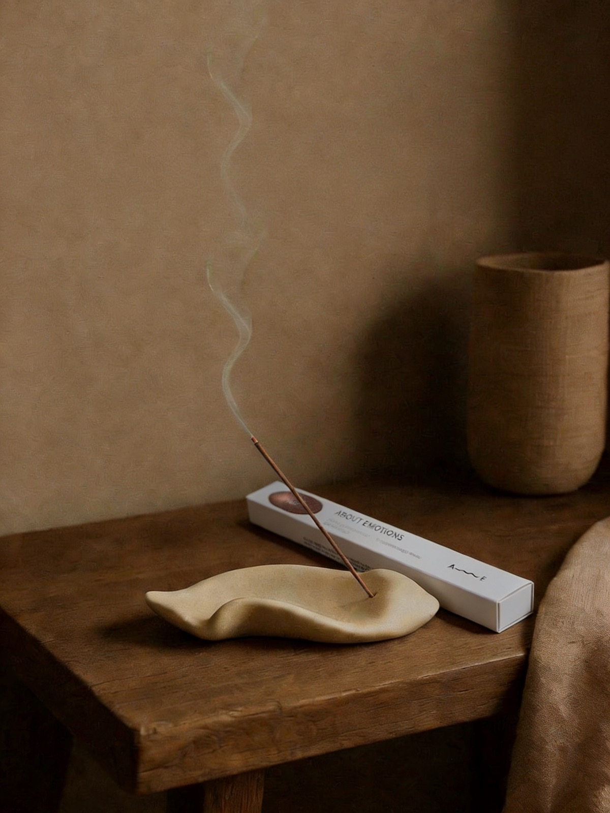 ABOUT EMOTIONS incense burning on a ceramic holder
